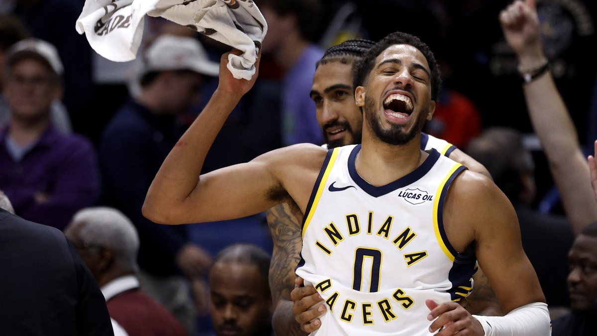 Tyrese Haliburton smiles and raises a towel while wearing a white Indiana jersey.