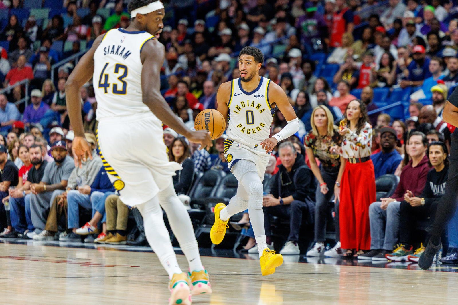 Tyrese Haliburton dribbles toward Pascal Siakam in white Pacers uniforms against New Orleans.