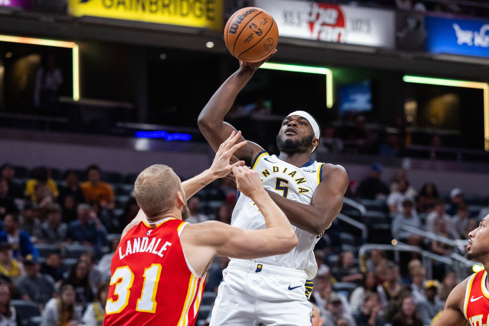 Jarace Walker in a white Pacers jersey rises for a shot over Atlanta's Jock Landale at Gainbridge Fieldhouse.