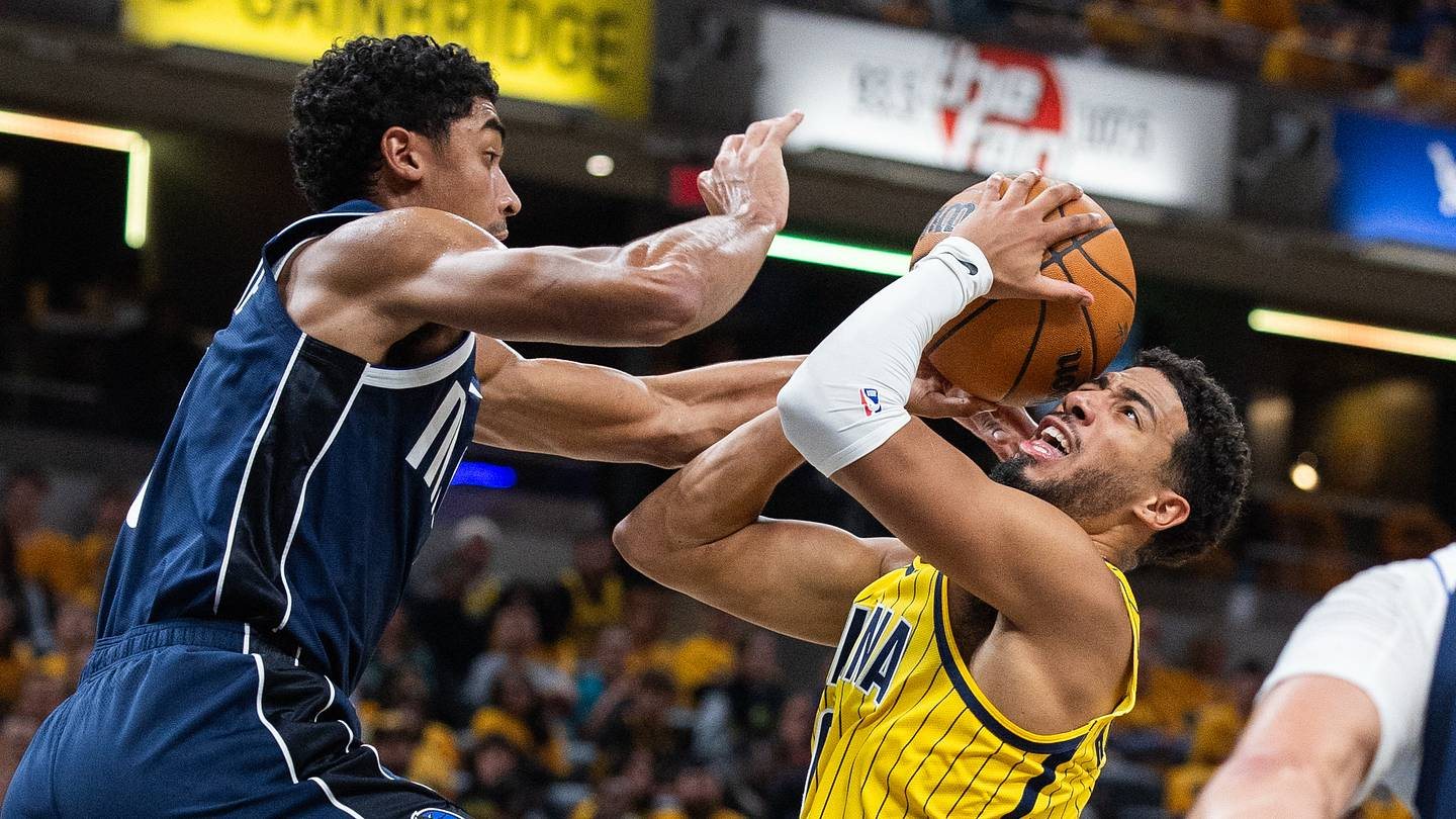 Tyrese Haliburton shoots in a yellow Pacers uniform as Dallas guard Max Christie contests.