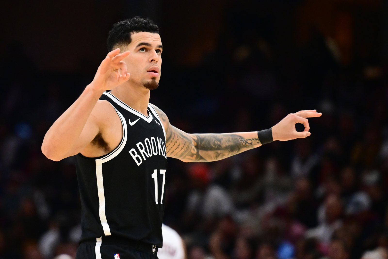 Michael Porter Jr. raises his hands in a black Brooklyn Nets jersey.